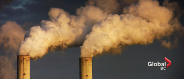 Smoke billowing out of two factory smoke stacks