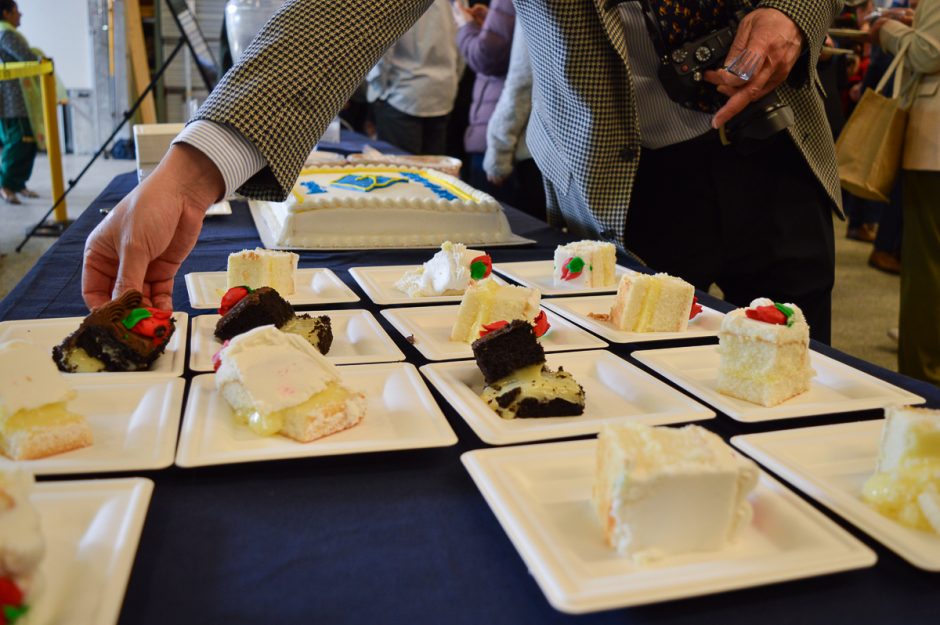 A guest picks up a slice of cake at the 2024 Mechanical Engineering Graduation Reception & Awards Ceremony.