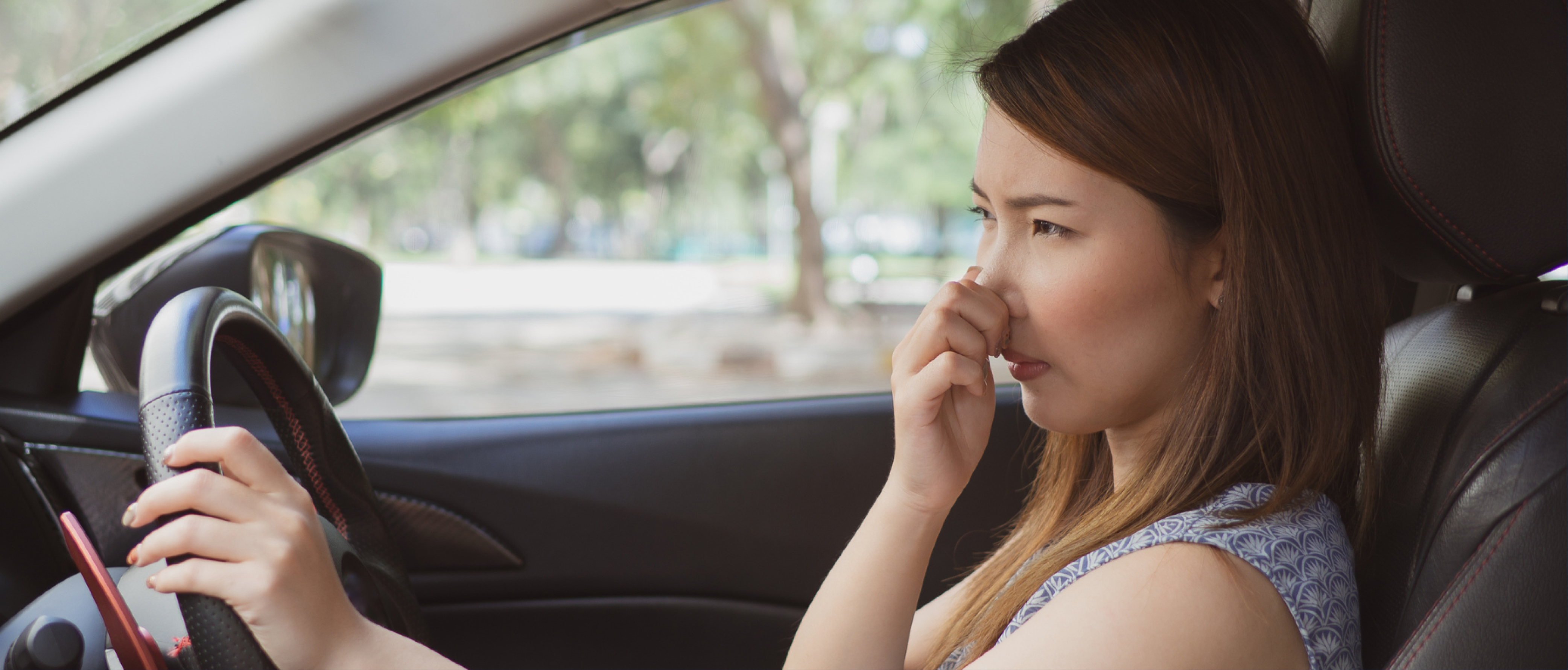 Woman in car experiencing bad smell